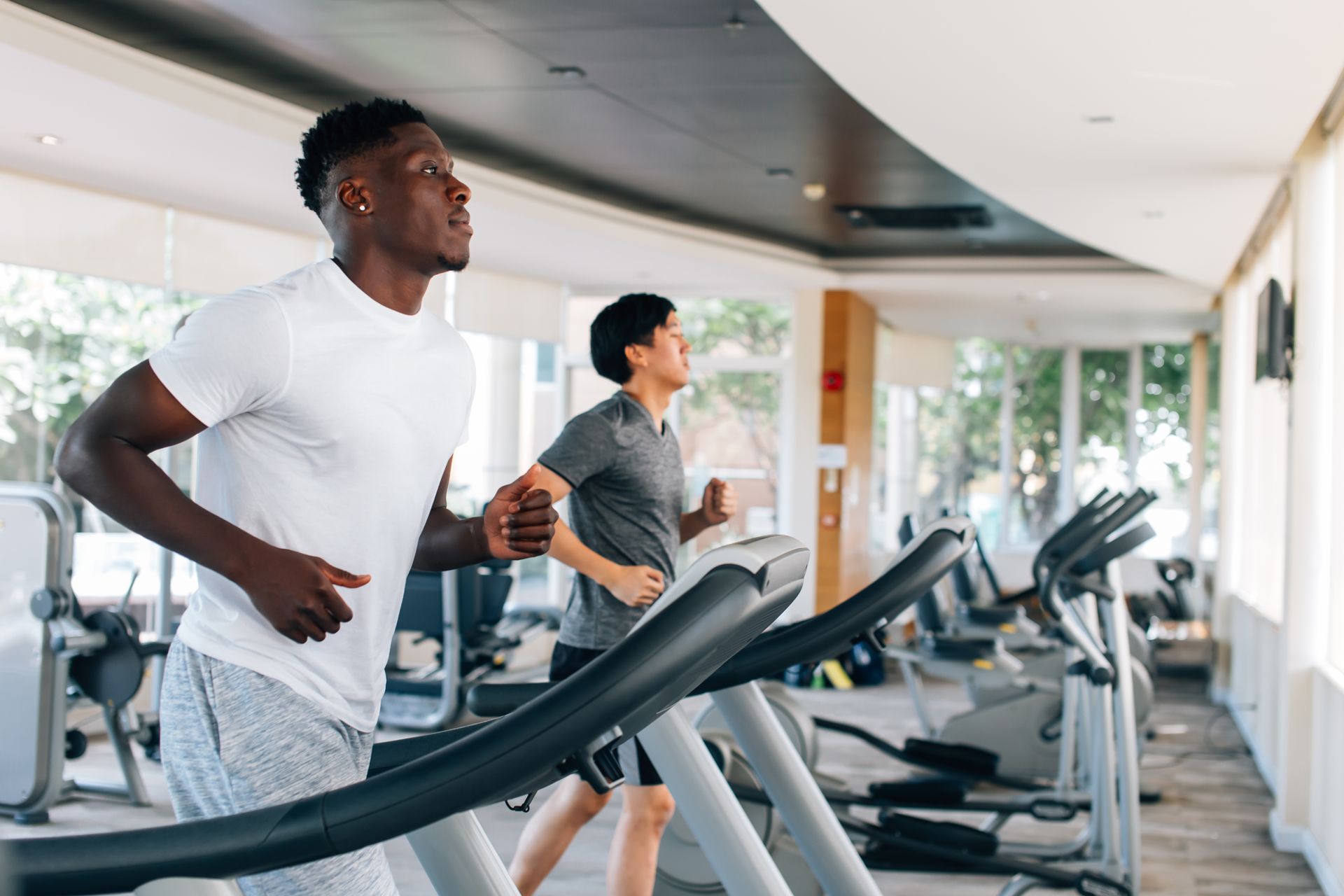 ethnic males running on treadmills