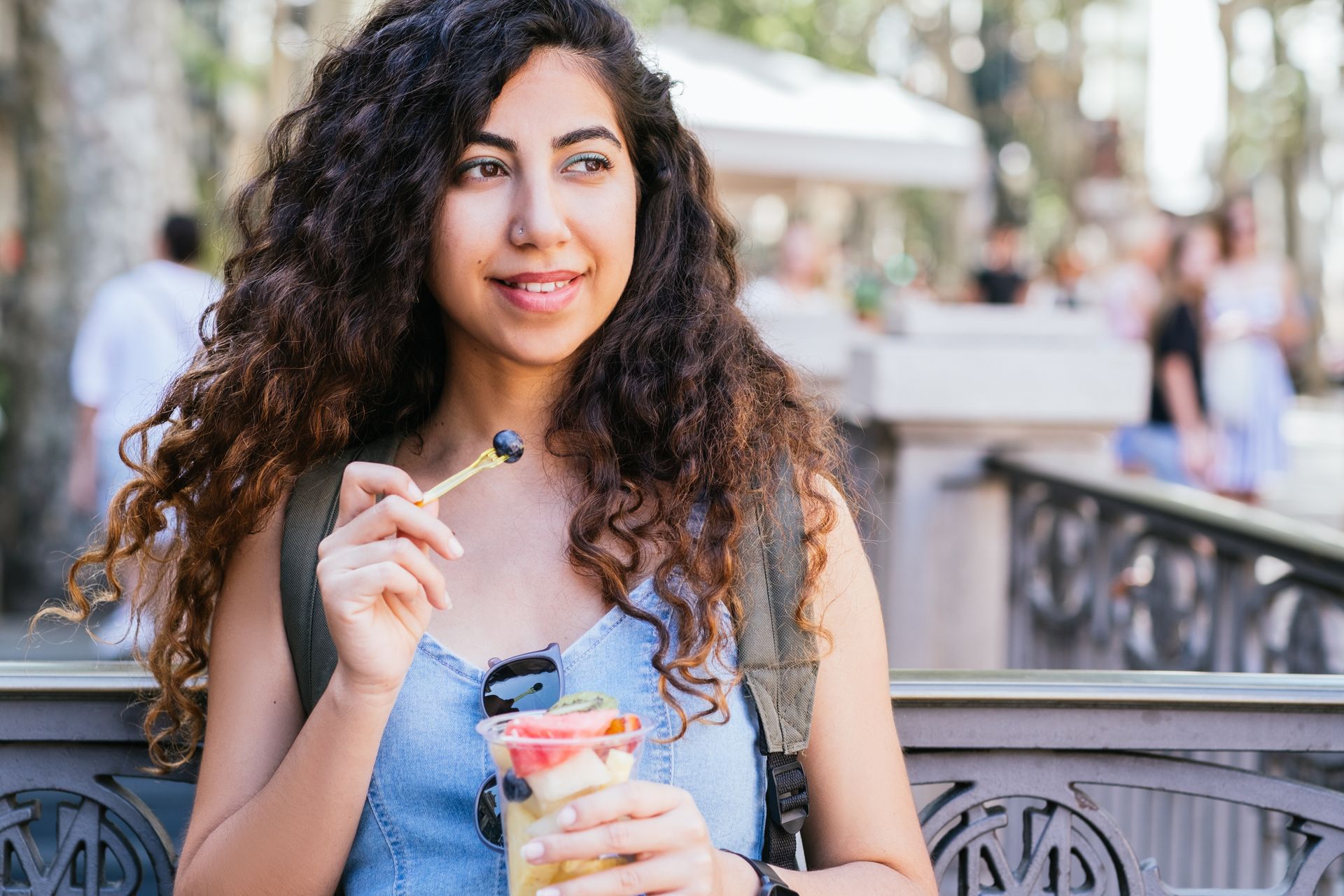 image of a woman eating a fruit cup