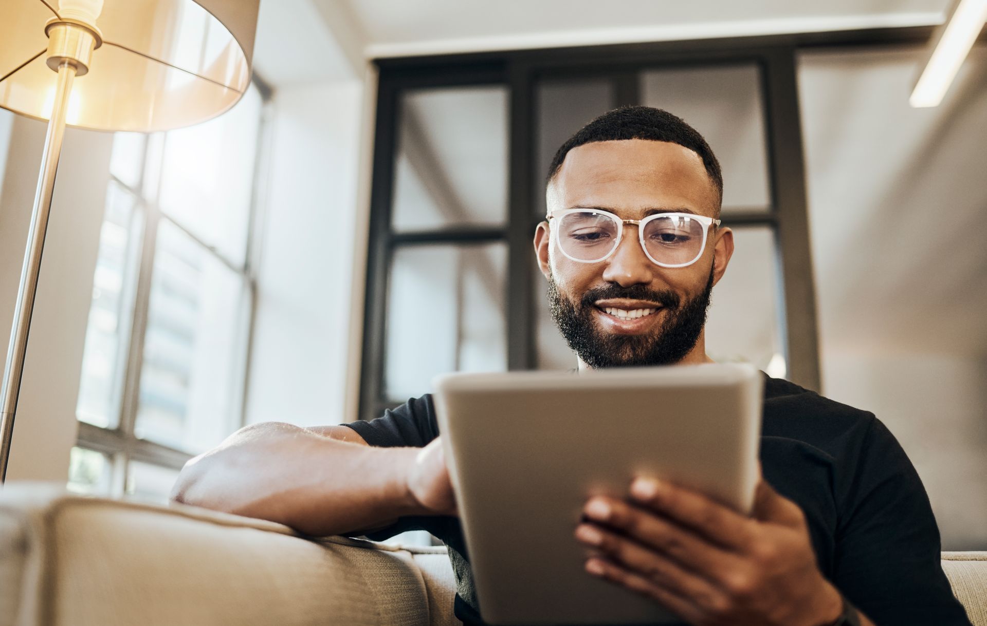 smiling man reading tablet